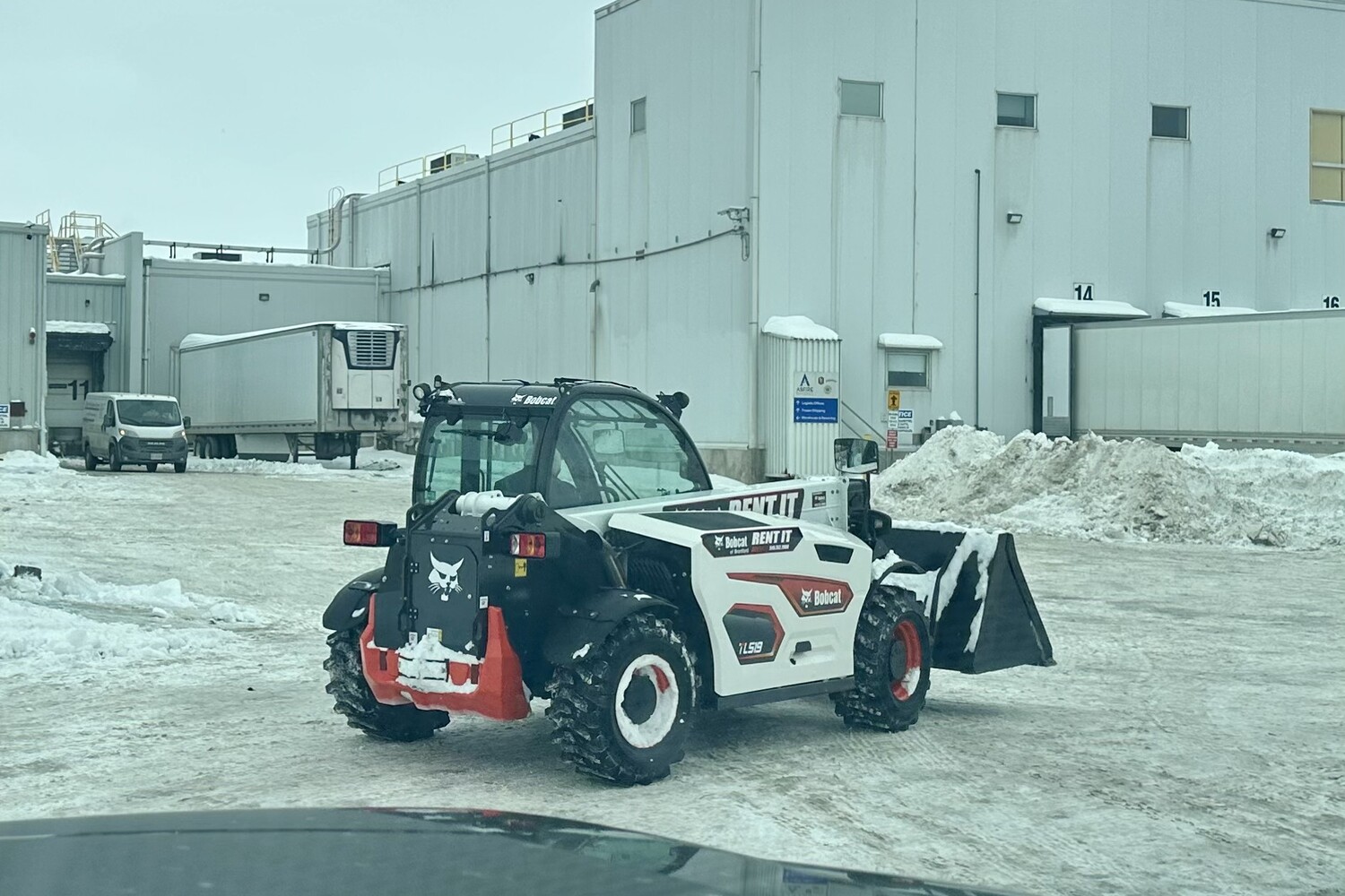 Bobcat TL519 telehandler clearing snow at an industrial commercial property in Brantford, Ontario.