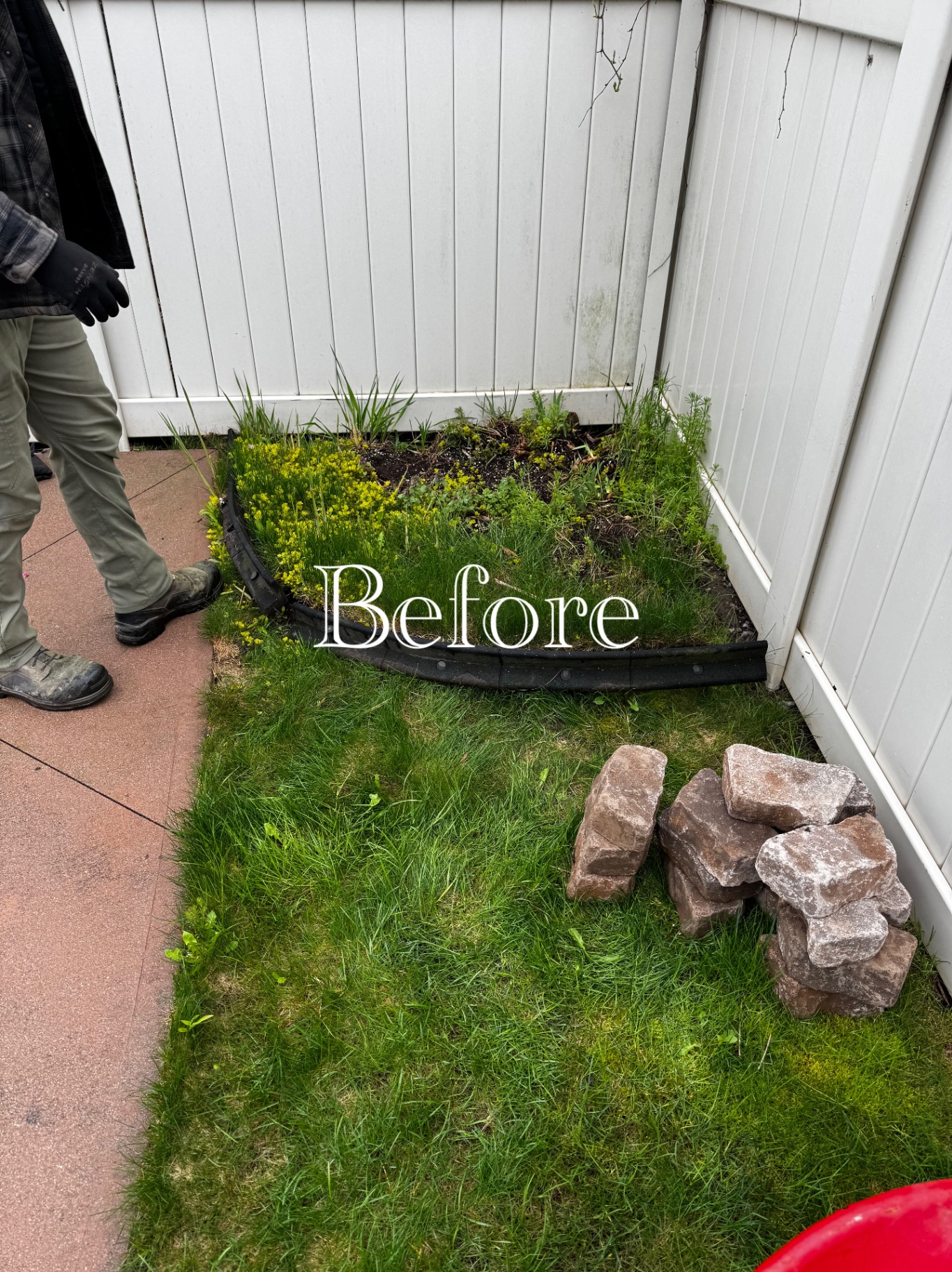 Overgrown corner garden bed with weeds and old plastic edging before rebuilding.